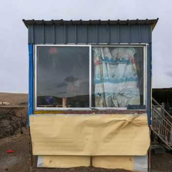 pexels-photo-20852648-20852648 Simple rural hut with colorful curtains in a barren landscape showcasing survival and simplicity.